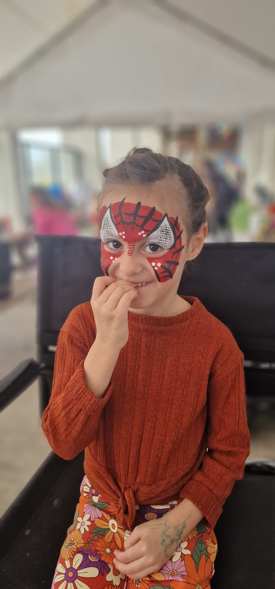 Meisje met een klassiek rood met zwart spidermanmasker over haar ogen