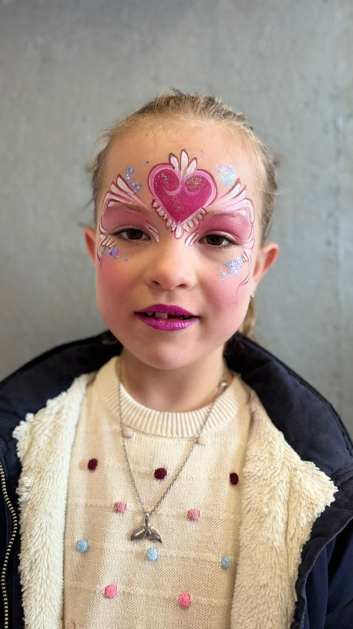 Meisje met een roze kroon met een hart erin en glitterstipjes langs haar ogen