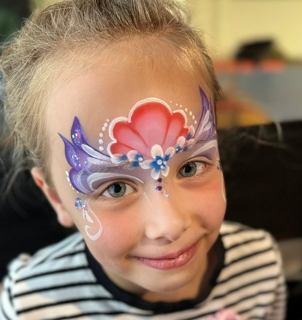 Meisje met een roze schelpkroon, paarse vleugels en kleine bloemetjes